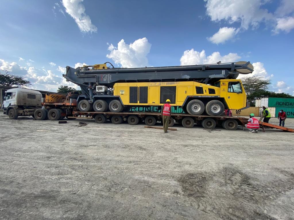 An out-of-gauge cargo module chained down on a multi-axle hydraulic trailer, loading crew alongside, during heavy-lift planning for green-hydrogen infrastructure