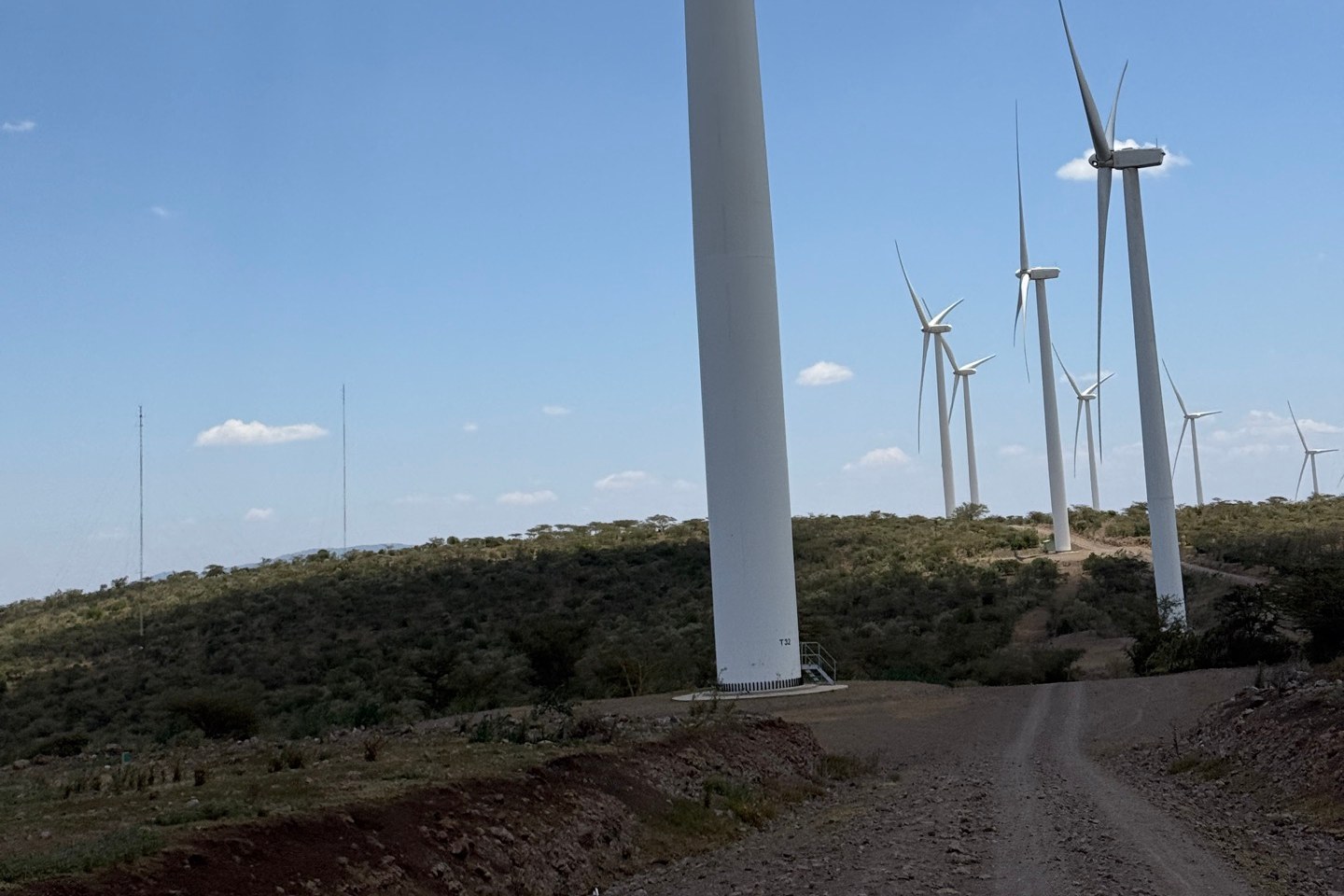 Wind turbines across a ridgeline, each reached by graded internal access roads