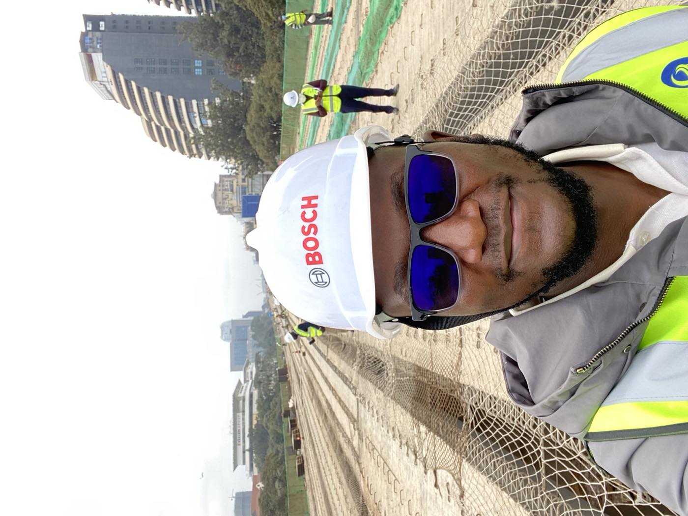 Eng. Victor Ombogo in hard hat and hi-vis, reviewing works on an active construction site