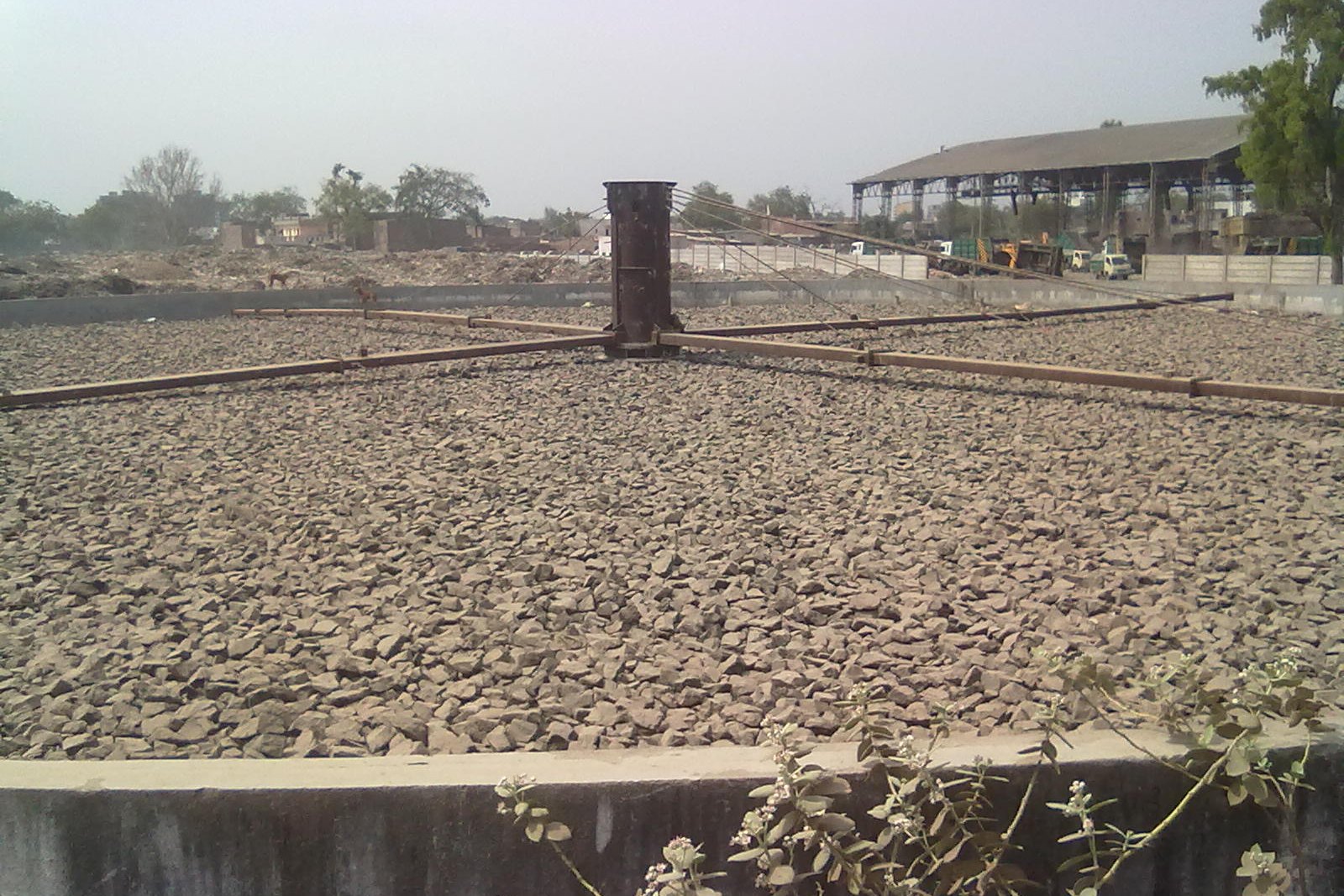 A circular trickling filter bed with rotary distributor arms at a municipal treatment works